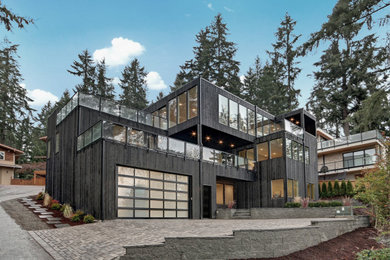 Large modern three-story wood exterior home idea in Seattle
