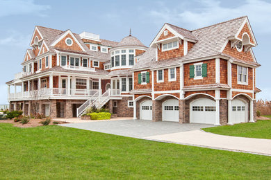 Aménagement d'une grande façade de maison marron bord de mer en bois à deux étages et plus avec un toit à deux pans et un toit en shingle.