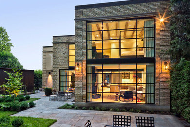Large contemporary beige two-story brick flat roof idea in Toronto