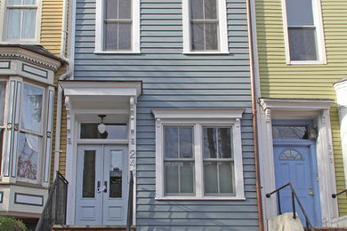 Idee per la facciata di una casa blu classica a tre piani con rivestimento con lastre in cemento