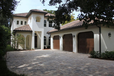 Inspiration for a large and beige mediterranean two floor render house exterior in Tampa with a hip roof.