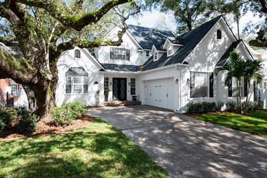 Large elegant white two-story brick house exterior photo in Tampa with a hip roof and a shingle roof