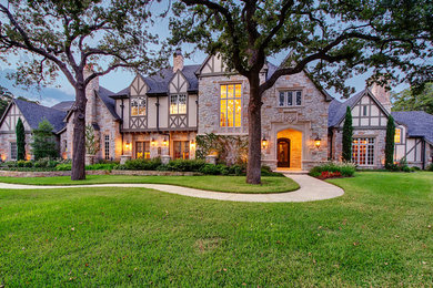 Example of a large classic two-story stone gable roof design in Dallas with a shingle roof