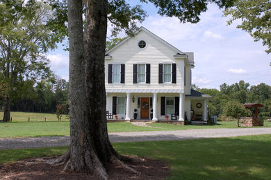 Réalisation d'une façade de maison blanche champêtre en panneau de béton fibré de taille moyenne et à un étage avec un toit à deux pans et un toit en shingle.