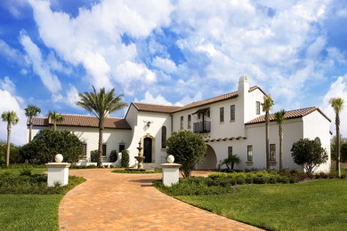 Imagen de fachada de casa beige de estilo americano de dos plantas con revestimiento de adobe