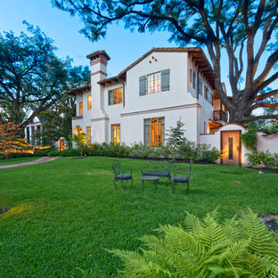 Large mediterranean white two-story stucco exterior home idea in Houston with a hip roof
