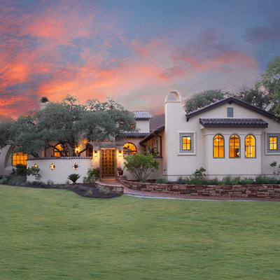 Large mediterranean white two-story stucco exterior home idea in Austin with a tile roof