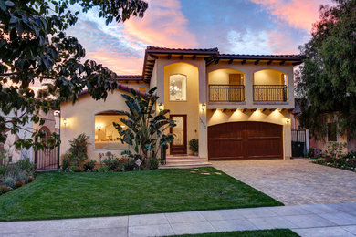 Large tuscan yellow two-story stucco house exterior photo in Los Angeles with a tile roof