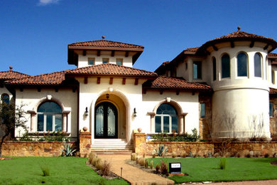 Imagen de fachada blanca mediterránea extra grande a niveles con revestimiento de estuco y tejado a cuatro aguas