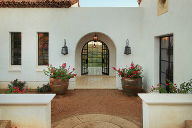 Example of a mid-sized tuscan one-story stucco exterior home design in Austin