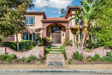 This is an example of a large and brown mediterranean two floor clay house exterior in Los Angeles.