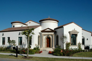 Large mediterranean white one-story stucco exterior home idea in Orlando