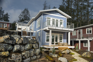 Modelo de fachada de casa azul clásica renovada de tamaño medio de dos plantas con revestimiento de aglomerado de cemento, tejado a dos aguas y tejado de metal