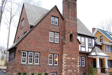 Example of a large classic three-story brick gable roof design in Cleveland
