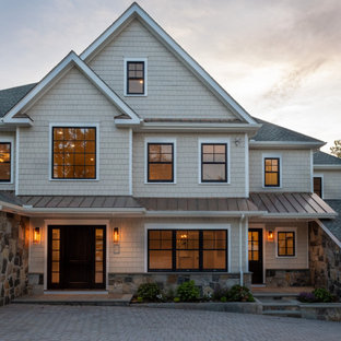 Example of a large transitional beige three-story exterior home design in New York with a shingle roof