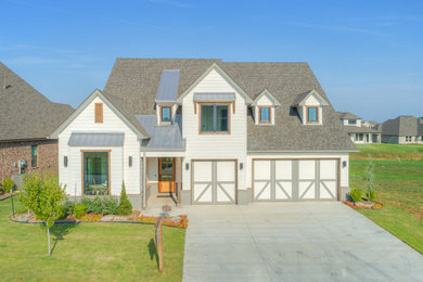 Modelo de fachada de casa blanca campestre de tamaño medio de dos plantas con revestimientos combinados, tejado a dos aguas y tejado de teja de madera