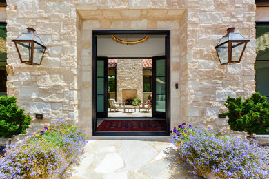 Example of a tuscan beige stone house exterior design in Kansas City