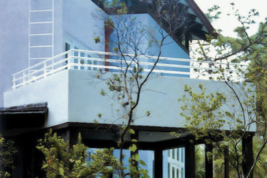 Foto de fachada de casa azul contemporánea grande de dos plantas con revestimiento de estuco, tejado a cuatro aguas y tejado de teja de madera