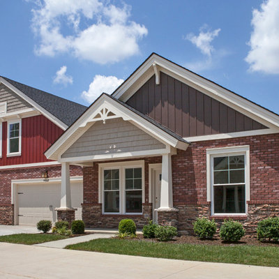 Example of a mid-sized arts and crafts red one-story brick exterior home design in Other with a shingle roof