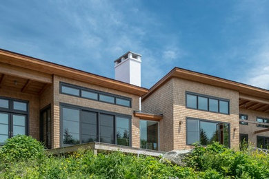 Idee per la facciata di una casa grande marrone contemporanea a un piano con rivestimento in legno e tetto piano