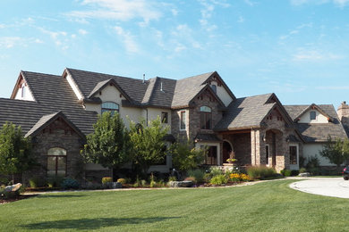 Mid-sized elegant beige two-story stucco gable roof photo in Denver