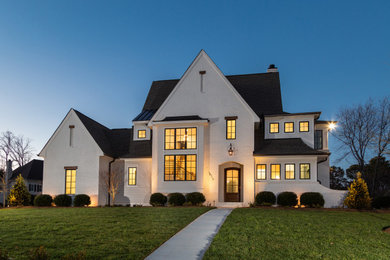 Example of a large transitional white two-story brick exterior home design in Charlotte with a shingle roof