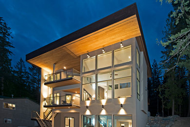 Diseño de fachada marrón contemporánea grande de tres plantas con revestimiento de estuco