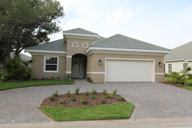 Example of a large transitional beige one-story stucco exterior home design in Orlando with a tile roof