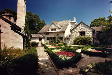 Modelo de fachada de casa blanca bohemia grande de dos plantas con revestimiento de estuco, tejado a dos aguas y tejado de teja de madera