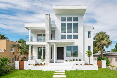 Diseño de fachada de casa blanca contemporánea grande de dos plantas con revestimiento de estuco y tejado plano