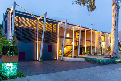 Foto de fachada de casa beige actual de tamaño medio de dos plantas con revestimiento de ladrillo y tejado plano