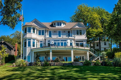 Example of a large beach style three-story mixed siding exterior home design in New York with a shingle roof