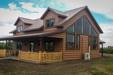 Immagine della villa marrone rustica a un piano di medie dimensioni con rivestimento in metallo, tetto a capanna e copertura in metallo o lamiera