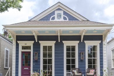 This is an example of a blue and small classic bungalow detached house in New Orleans with wood cladding, a mansard roof and a shingle roof.