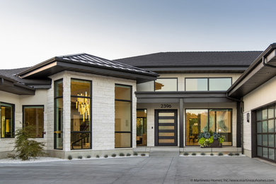 Large modern white two-story stone house exterior idea in Salt Lake City with a hip roof and a shingle roof