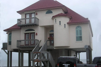 This is an example of a beige classic render house exterior in Houston with three floors.