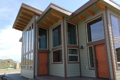 Diseño de fachada de casa verde contemporánea de tamaño medio de dos plantas con revestimiento de madera y tejado de un solo tendido