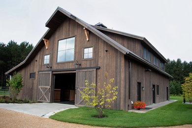 Foto de fachada marrón rural grande de dos plantas con revestimiento de madera, tejado a dos aguas y tejado de metal