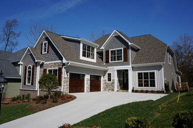 Example of a mid-sized arts and crafts gray two-story mixed siding gable roof design in Other
