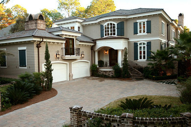 Modelo de fachada de casa beige clásica de tamaño medio de dos plantas con revestimiento de vinilo, tejado a dos aguas y tejado de teja de madera