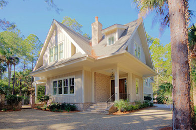 Пример оригинального дизайна: двухэтажный, бежевый дом среднего размера в классическом стиле с комбинированной облицовкой и двускатной крышей
