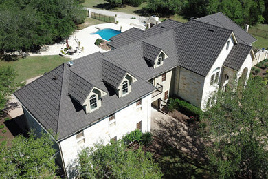 Modelo de fachada de casa tradicional grande de dos plantas con tejado a cuatro aguas y tejado de metal