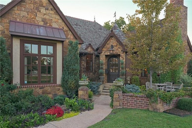 Example of a mid-sized classic brown two-story stone exterior home design in Other with a shingle roof