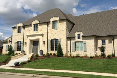 Example of a large classic beige two-story brick exterior home design in Other