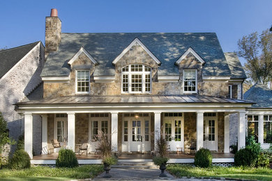 Large traditional brown two-story stone exterior home idea in Nashville with a shingle roof