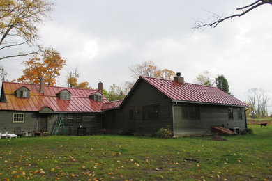 Medium sized and brown rural bungalow house exterior in New York with wood cladding.