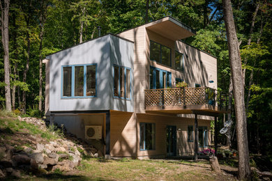 Example of a mid-sized mountain style split-level wood house exterior design in New York