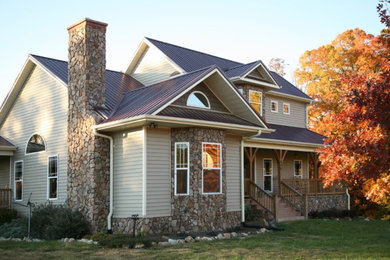 Ejemplo de fachada de casa rústica de tamaño medio de dos plantas con revestimiento de piedra