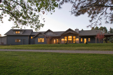 Ejemplo de fachada verde de estilo de casa de campo de tamaño medio de una planta con revestimientos combinados y tejado a dos aguas