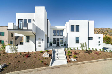 Идея дизайна: двухэтажный, белый частный загородный дом среднего размера в стиле модернизм с облицовкой из цементной штукатурки и плоской крышей